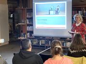 Eine Frau hält eine Präsentation vor einer Gruppe von Menschen.